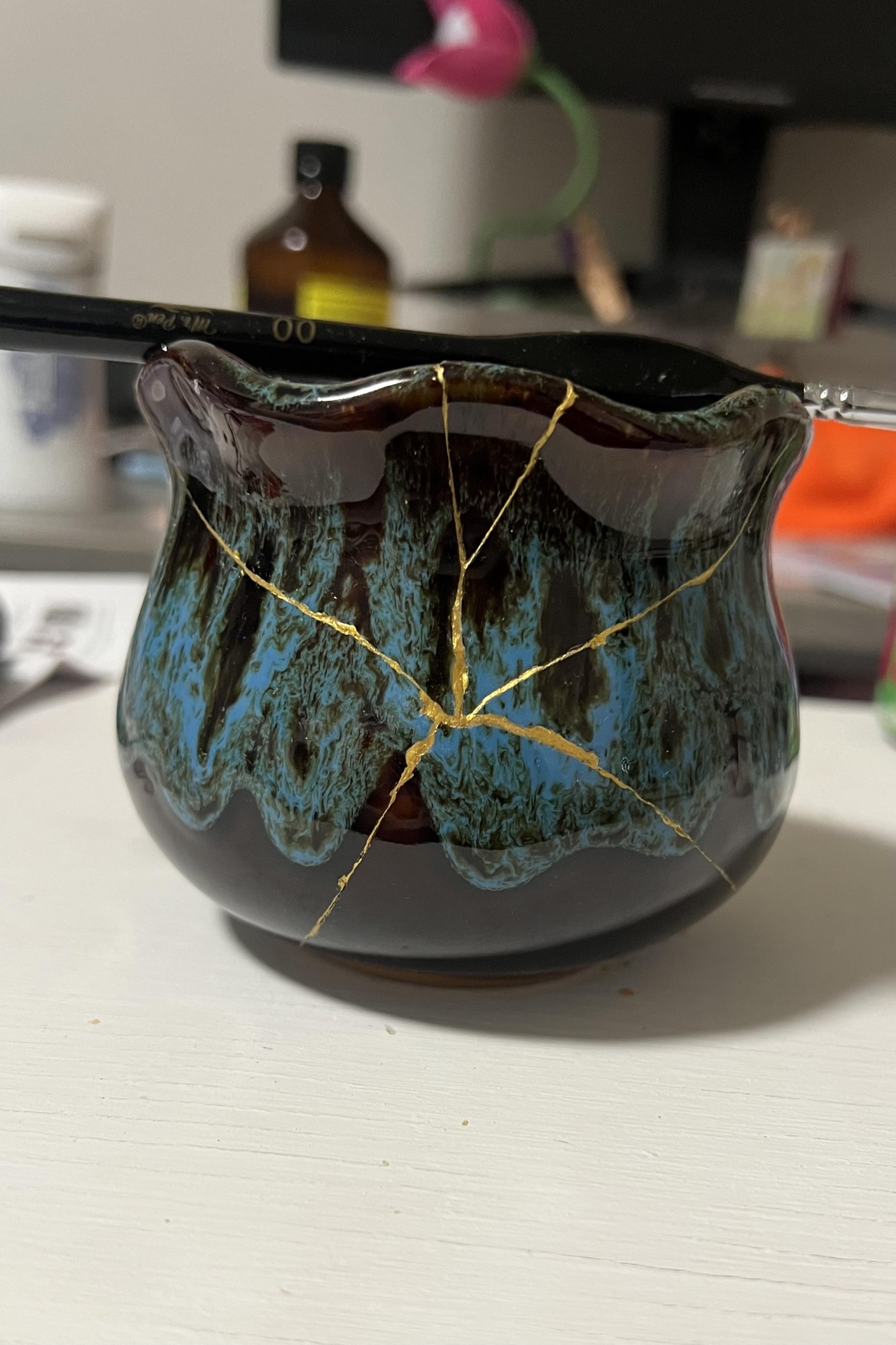 Kintsugi ceramic vessel with gold repair lines